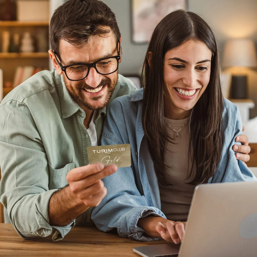 Casal a consultar o cartão TURIM Club Gold no computador
